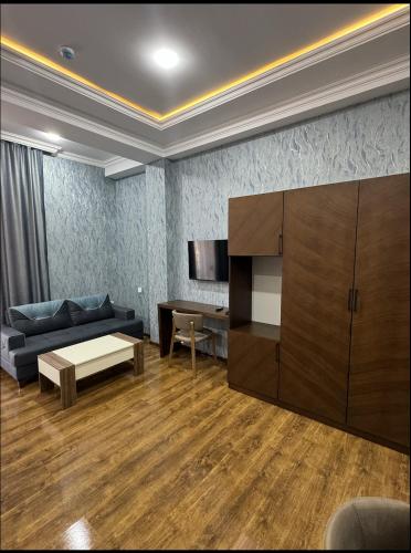 a living room with a couch and a table at Buta Hotel Berde in Bǝrdǝ