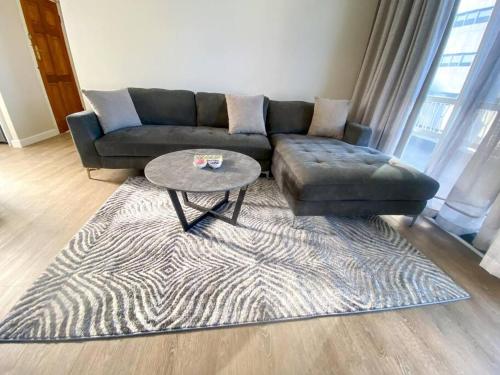 a living room with a couch and a coffee table at Spacious 2-bed unit no-powercuts in Cape Town