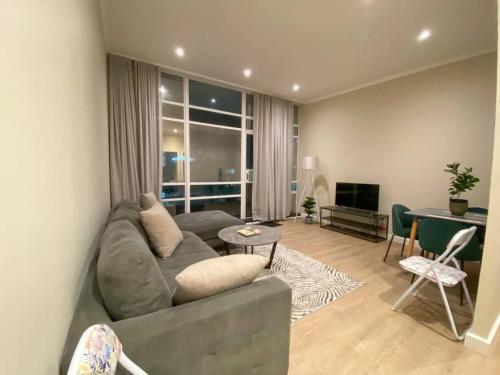 a living room with a couch and a table at Spacious 2-bed unit no-powercuts in Cape Town