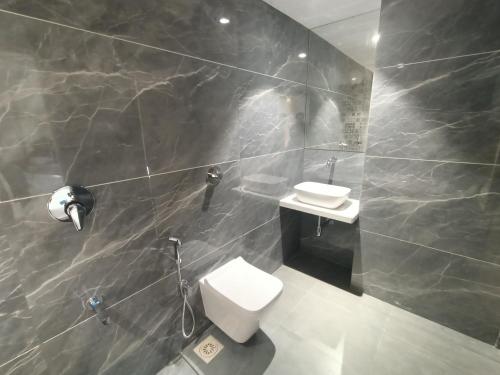a bathroom with a toilet and a sink at Hotel Pearl Residency Thane in Thane