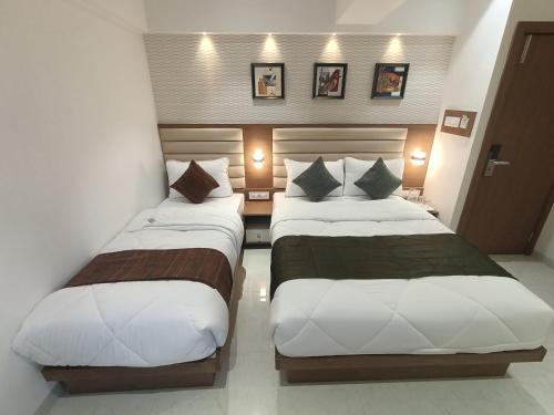 two beds in a hotel room next to each other at Hotel Pearl Residency Thane in Thane