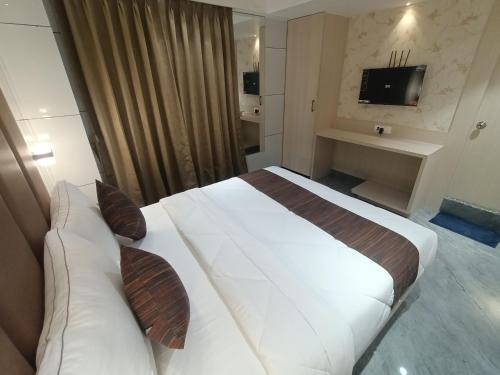 a hotel room with a large bed and a couch at Hotel Pearl Residency Thane in Thane