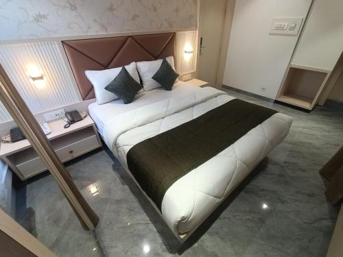 a large bed in a hotel room with two tables at Hotel Pearl Residency Thane in Thane