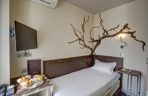 um quarto com uma cama com uma árvore na parede em Hotel Vivaldi em Puteaux