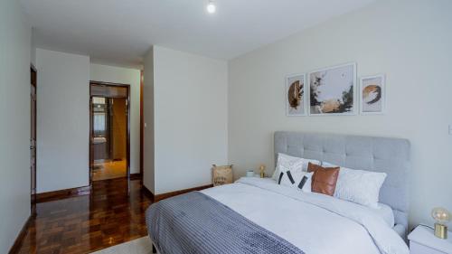 um quarto com uma cama grande e lençóis brancos em Exquisite 2 Bedroom, Lux Living at Riverside em Nairobi