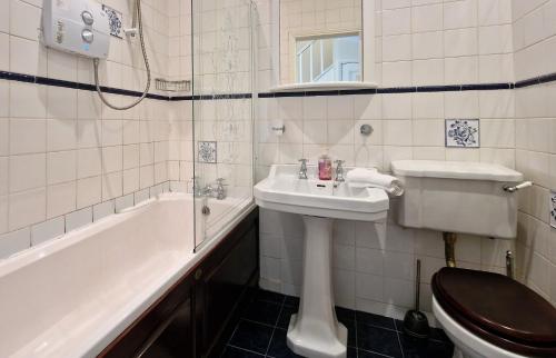 a bathroom with a sink and a toilet and a tub at Walking distance to Grafton St in Dublin
