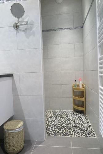 La salle de bains est pourvue d'une douche et d'un sol noir et blanc. dans l'établissement Pietra Bella, à LʼÎle-Rousse