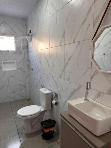 een witte badkamer met een toilet en een wastafel bij Bela Beach in São José da Coroa Grande