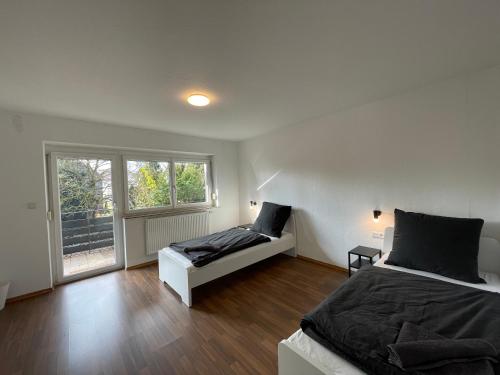 a bedroom with two beds and a window at Worker Apartments near Ulm bis zu 11 Betten in Dornstadt