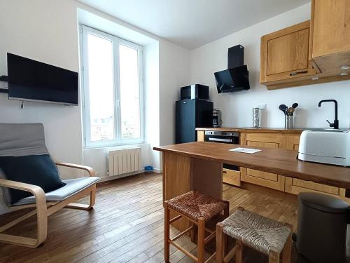 une cuisine avec une table et des chaises dans une pièce dans l'établissement Appartement au centre de TREBEURDEN et à 400m de la plage - Réf 662, à Trébeurden