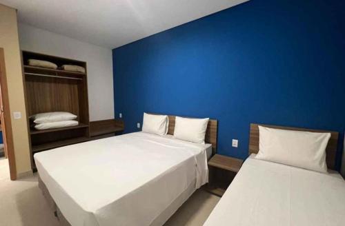 - une chambre avec 2 lits et un mur bleu dans l'établissement São Pedro Thermas Resort, 