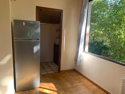 um frigorífico de aço inoxidável num quarto com uma janela em Hostellerie la Fuste N 17 em Valensole