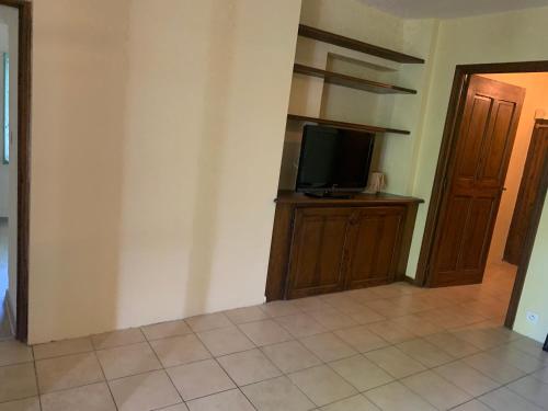 una habitación con TV en un soporte de madera con un tvicteterictericétrico en Hostellerie la Fuste N 17, en Valensole