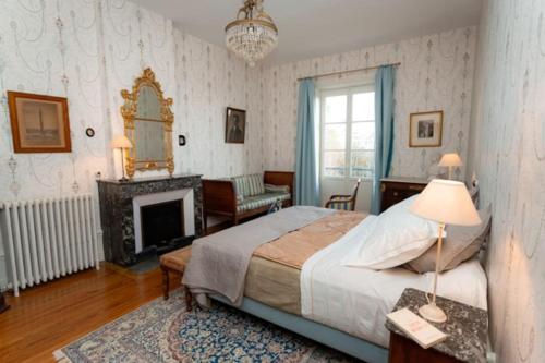1 dormitorio con 1 cama grande y chimenea en gîte ou chambres d'hôtes au château de Montclair, en Pommiers
