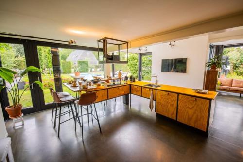 a kitchen with a island with a sink and chairs at Fabulous 4 Bedroom Villa (KS-10) in Eindhoven