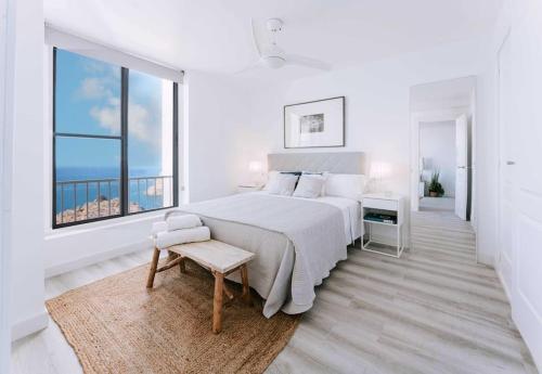 um quarto branco com uma cama grande e uma janela em Apartamento balcón del Mar em Almeria