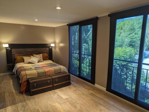 1 dormitorio con 1 cama y ventanas grandes en Citizen Kane Lodge - Hospedaje Gourmet en San Carlos de Bariloche