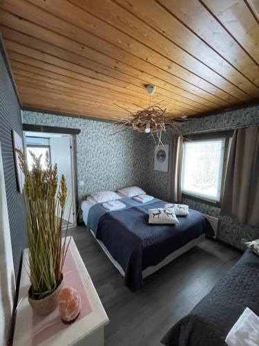 a bedroom with a bed and a wooden ceiling at Beautiful rural experience with reindeer in Tervola