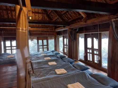a large bed in a room with windows at Ta Xua Ecolodge in Bắc Yên