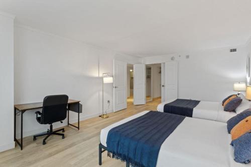 a hotel room with two beds and a desk at Beachfront 2BR 3BA Condo by CozySuites in Atlantic City