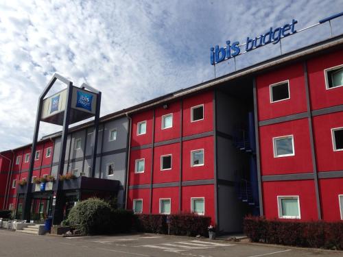 un bâtiment rouge avec un panneau dessus dans l'établissement ibis budget Strasbourg La Vigie, à Ostwald