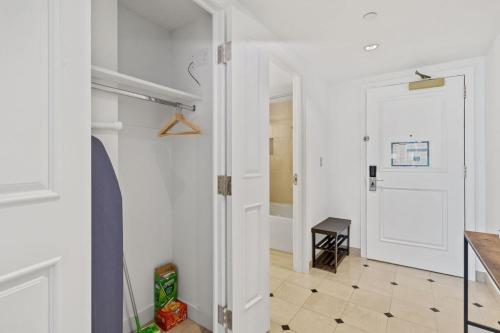 a white hallway with a white door and a table at Beachfront 2BR 3BA Condo by CozySuites in Atlantic City