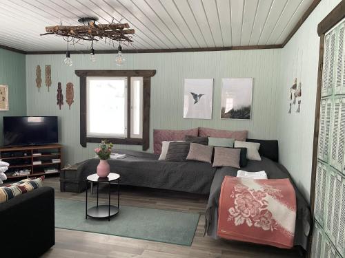 een woonkamer met een bed en een bank bij Beautiful rural experience with reindeer in Tervola