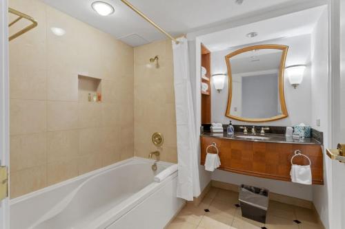 a bathroom with a tub and a sink and a mirror at Beachfront 2BR 3BA Condo by CozySuites in Atlantic City