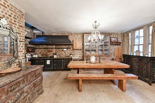 cocina grande con mesa de madera y lámpara de araña en Knightsbridge 2BR Mews House, en Londres