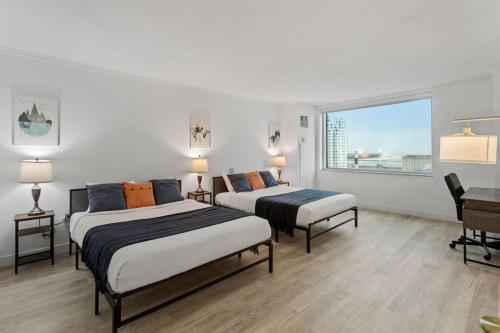 2 camas en una habitación blanca con ventana en CozySuites at Showboat 1BR 2BA OceanFront Villa, en Atlantic City