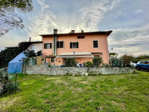 a large pink house in a field with a yard at A casa della nonna in Seano