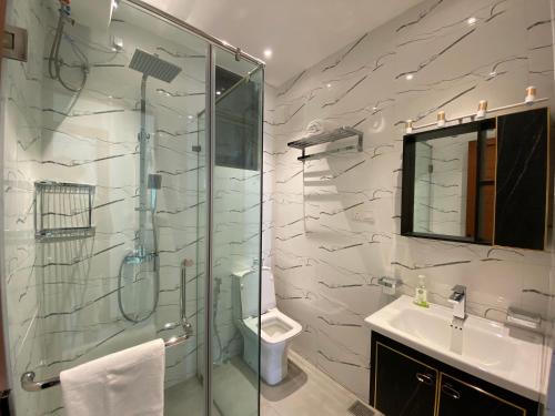 a bathroom with a shower and a toilet and a sink at Marine Breeze Residencies in Colombo