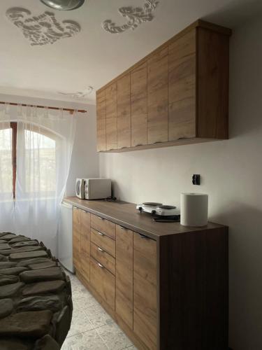 a kitchen with wooden cabinets in a bedroom at Magurska enklawa- domek letniskowy in Nowy Żmigród