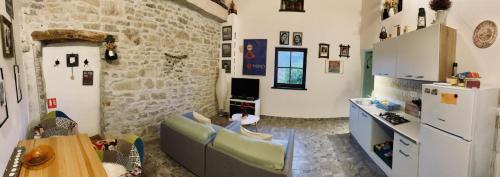 a living room with a couch and a stone wall at Lucky Home - Apartment Art Grožnjan in Grožnjan