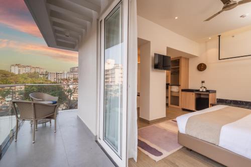 Marmagao的住宿－Regenta Place Vasco Goa，一间带特大号床的卧室和一个阳台