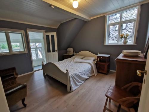 una camera con un letto e due finestre di Sjarmerande hus i Eidsgata a Nordfjordeid