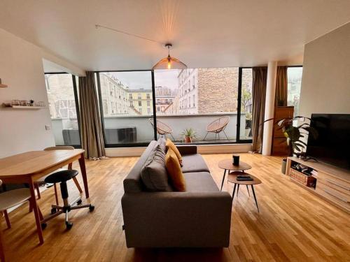 a living room with a couch and a table at 5P Chic Apt, Rooftop, Paris in Paris
