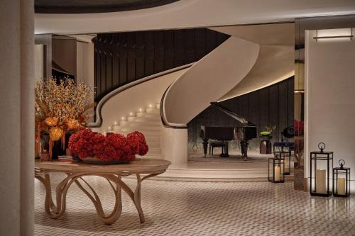a living room with a table and a piano at Regent Shanghai on the Bund in Shanghai