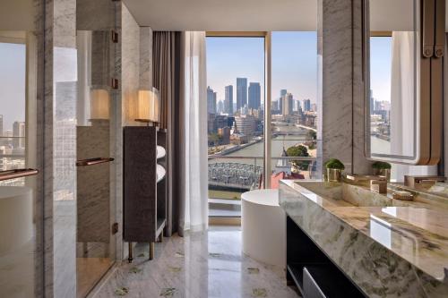 a bathroom with a tub and a view of the city at Regent Shanghai on the Bund in Shanghai