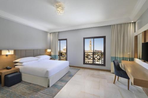 a hotel room with a bed and a desk and a desk at Four Points by Sheraton Makkah Al Naseem in Makkah