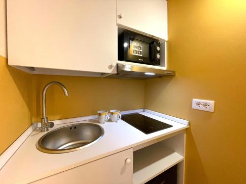 a small kitchen with a sink and a microwave at Casa Federica alloggi turistici in Isola del Liri