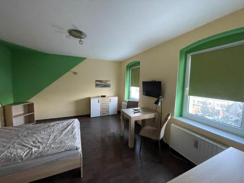 um quarto com uma cama, uma secretária e uma televisão em Gästewohnung in Forst (Lausitz) 