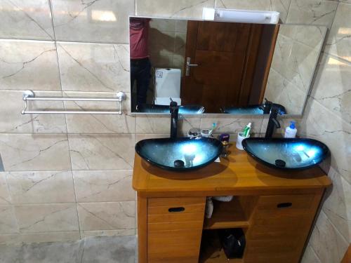 baño con 2 lavabos y espejo grande en Maison d'architecte moderne, en Abomey-Calavi