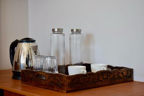 bandeja de madera con tazas y botellas en una mesa en Humming Bird By Aaryam, en Ukhimath