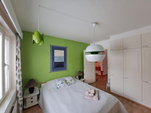 a green bedroom with a bed and a green wall at Back to Retro Yyterissä in Pori