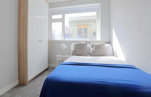 1 dormitorio con cama azul y ventana en 2 Bed City Centre Apartment en Dublín