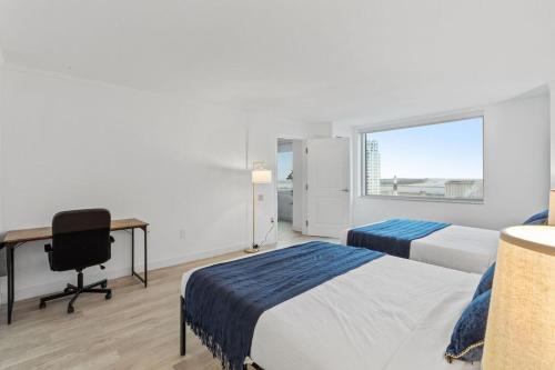 a bedroom with two beds and a desk and a window at 2BR 3BA CozySuites Hard Rock and Ocean Casino in Atlantic City