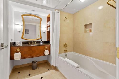 a bathroom with a tub and a sink and a mirror at 2BR 3BA CozySuites Hard Rock and Ocean Casino in Atlantic City