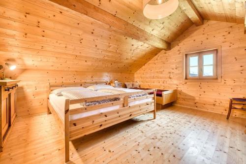 a bedroom with a large bed in a wooden room at Berghaus Kessler in Vandans