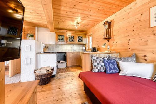 una sala de estar con un sofá rojo en una cabaña en Berghaus Kessler, en Vandans